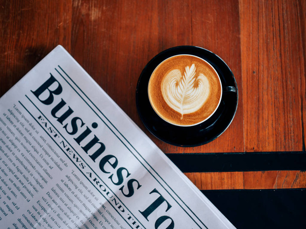 Top view of coffee latte art and news paper  in coffee shop cafe - Фото, зображення