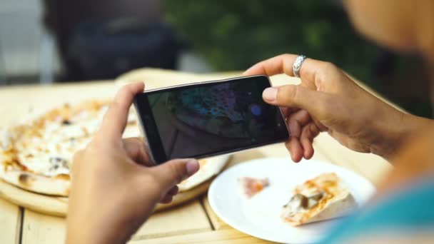 Θηλυκό Food Blogger λαμβάνοντας φωτογραφίες από πίτσα από το κινητό τηλέφωνο σε πιτσαρία - Πλάνα, βίντεο