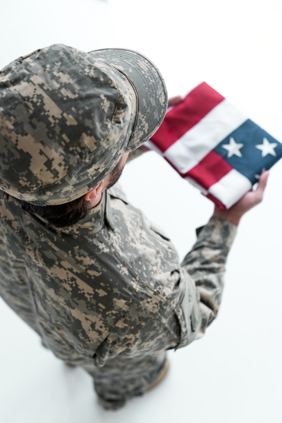 overhead view of male soldier in military uniform with american flag in hands - Foto, Bild