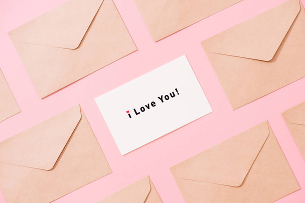 Rám z obálky a pohlednice na růžové tabulka pohled shora. Slova Miluji tě. Valentine koncept. Rozložení bytu. - Fotografie, Obrázek