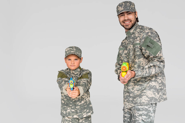 portrait of family in military uniform with water guns in hands isolated on grey - Photo, Image