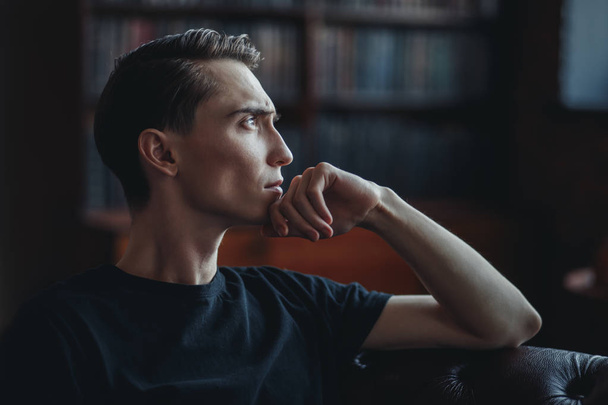 Close-up portrait of a handsome pensive young man in a room. Men's beauty and health. - Φωτογραφία, εικόνα