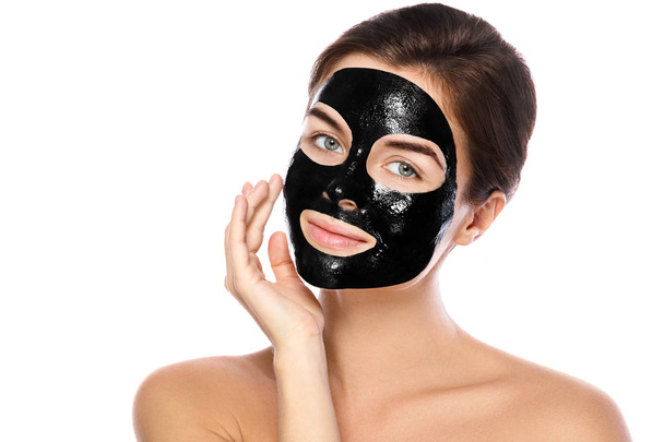 彼女の顔に浄化ブラック マスクと美しい女性。白い背景に分離 - 写真・画像