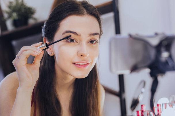 Young beautiful woman filming video about eye mascara - Foto, Imagen