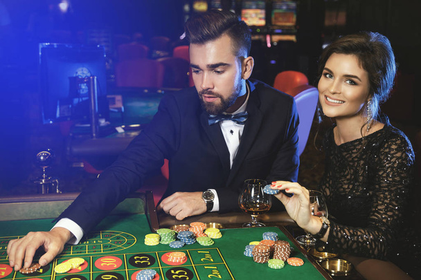 Beautiful and well dressed couple playing roulette in the casino - Foto, Imagem