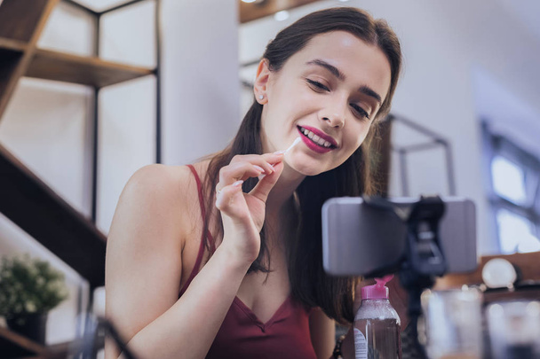 Dark-haired cheerful woman fixing her makeup - Fotografie, Obrázek