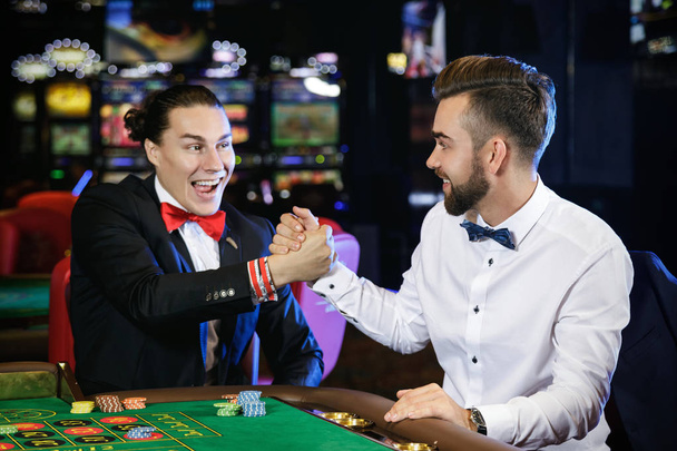 Two handsome guys playing roulette in the casino - Foto, Bild