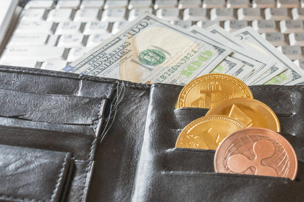 a purse with dollars and a crypto currency. Crypto currency. Coins Bitcoin BTC, dollars sticking out of a man's black leather purse.Blockchain.Intarnational currency.Top view.E-commerce - Zdjęcie, obraz