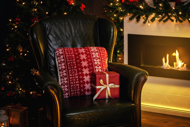 Christmas gifts and armchair beside the fireplace - Photo, Image