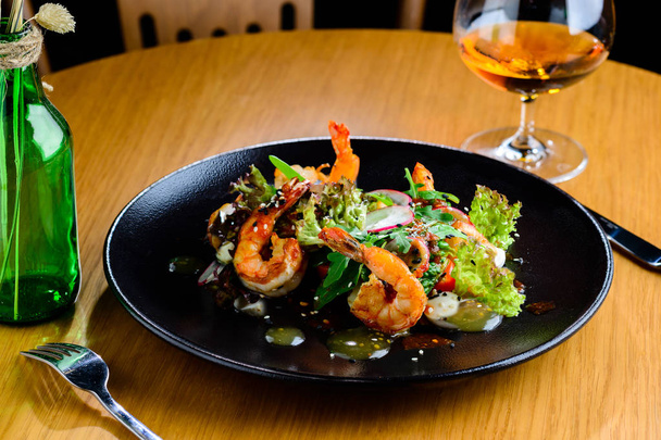 Appetizing spicy salad with shrimps, radish and sauce on the tab - Photo, Image