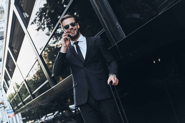 happy businessman in suit talking on mobile phone outdoors - Foto, Imagen