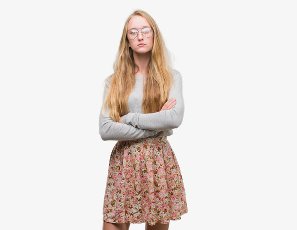 10 代の金髪女性の身に着けている花スカートの懐疑論者と組んだ腕で顔の神経、不賛成の式。否定的な人. - 写真・画像