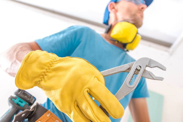 Caucasian Construction Worker with Plier is About To Fix Something. - Foto, Bild