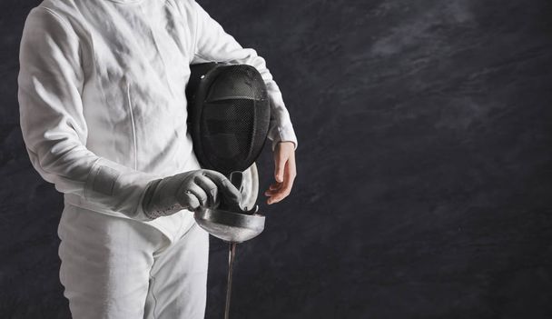 Female fencer in white fencing suit at black background - Фото, изображение