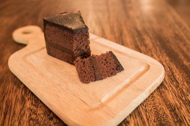 Fermer Tranche de gâteau au chocolat avec grenouille sur table en bois
. - Photo, image