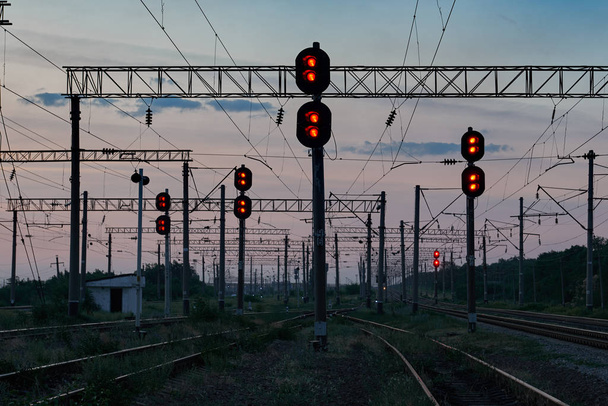 semáforos ferroviarios e infraestructura durante el hermoso atardecer, cielo colorido, transporte y concepto industrial
 - Foto, Imagen