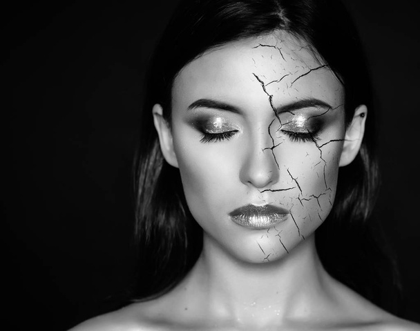 Woman with cracked face as cosmetic and dehydration effect concept. - Foto, Imagen