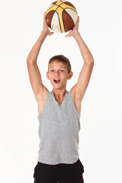 teenager with a basketball on a white background - Valokuva, kuva