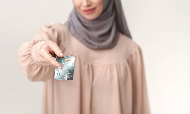 Transacción sin efectivo, mujer árabe que da tarjeta de crédito
 - Foto, imagen