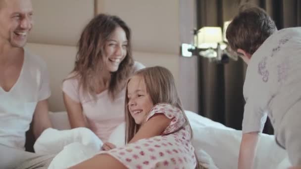 Happy Children Jump In Their Parents Bed In The Morning - Filmati, video