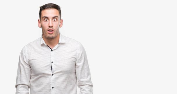 Handsome young business man scared in shock with a surprise face, afraid and excited with fear expression - 写真・画像