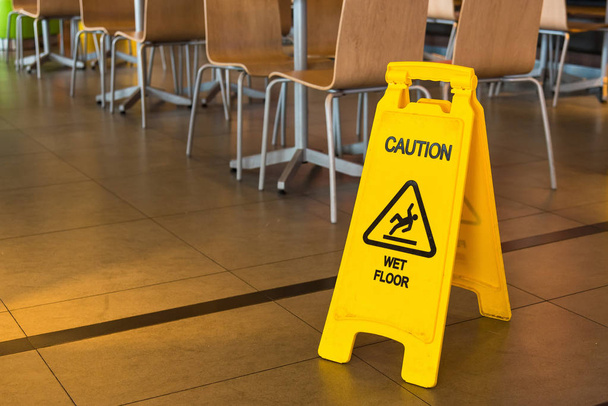 Κίτρινο σημάδι που προειδοποιεί για υγρό πάτωμα στο εστιατόριο. Ταϊλάνδη - Φωτογραφία, εικόνα
