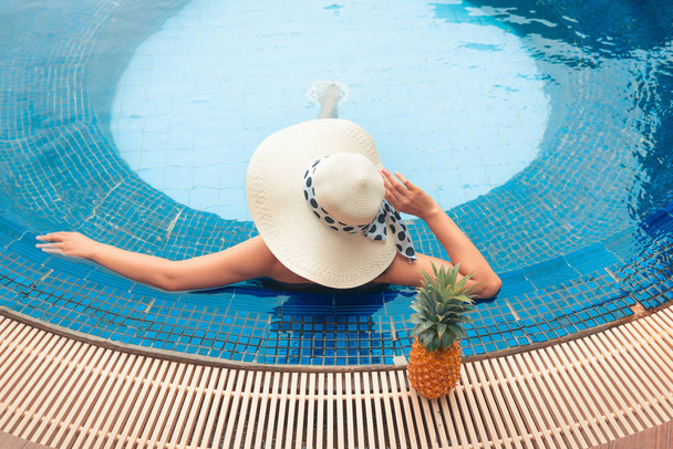 Το καλοκαίρι η έννοια, Ασιατικές γυναίκα χαλαρώνοντας στην πισίνα. - Φωτογραφία, εικόνα