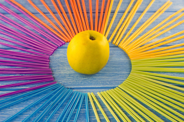 Yellow apple and drinking straws on a wooden background - Φωτογραφία, εικόνα