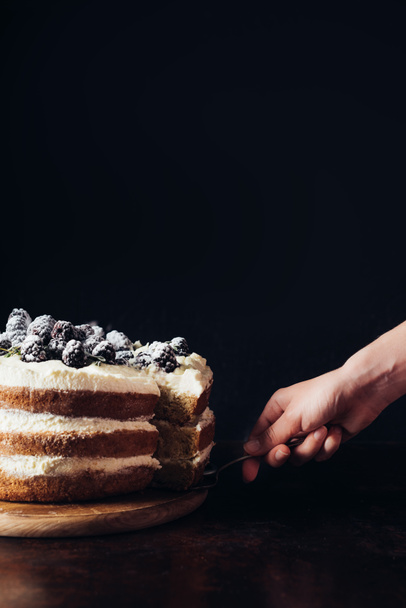 cropped shot of woman serving delicious blackberry cake on black - 写真・画像