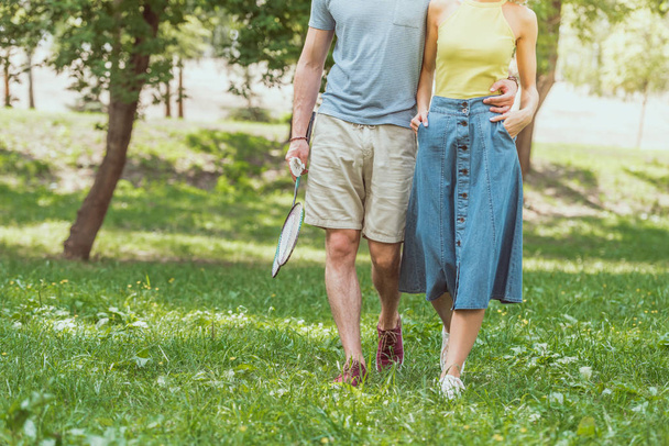 cropped image of couple walking with badminton rackets and shuttlecock to play in park - Φωτογραφία, εικόνα