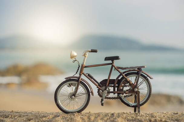 夕方の夕焼け空砂海のビーチで自転車交通グッズ  - 写真・画像