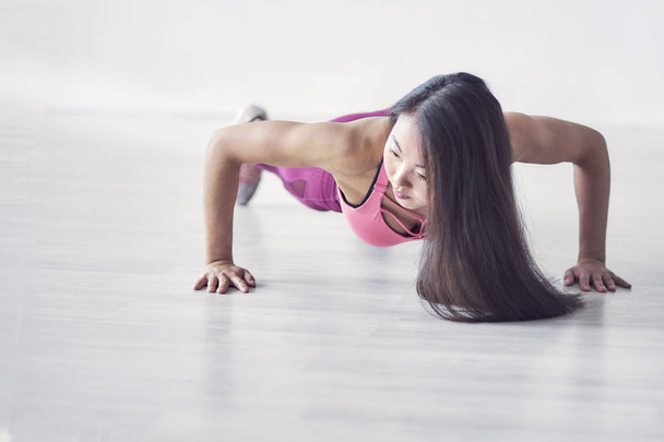 Urheilullinen Aasian naiset liikunta sisätiloissa kotona hän on toiminut "push up". päättynyt lenkkeily
 - Valokuva, kuva
