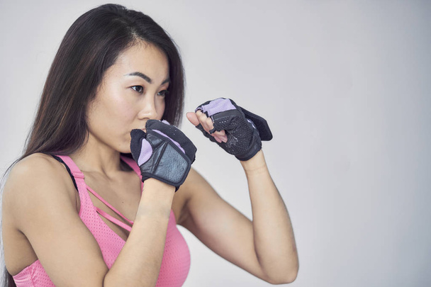 Asian woman boxing exercise with hands wrap. Beauty face and natural makeup sports bra outfit. - Photo, Image