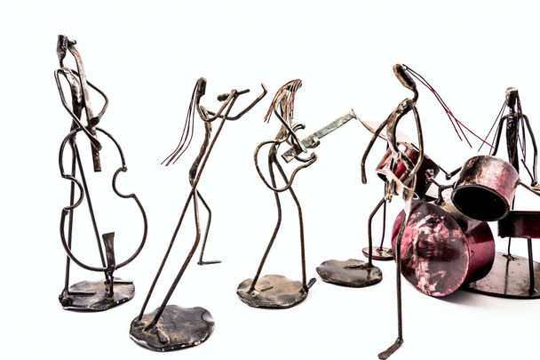 Фигуры музыкальных исполнителей, сделанные из сварной черной металлической проволоки. Группа в составе: гитарист, бас-гитарист, дружина и певец играют вместе. Живые линии
 - Фото, изображение