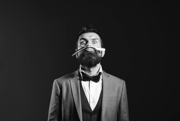 Business and barbershop service concept. Macho in formal suit shaves beard. Businessman with funny grimace - Valokuva, kuva