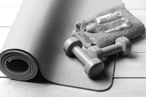 Sports and healthy lifestyle concept, Barbells near water bottle and soft towel on yoga mat - Φωτογραφία, εικόνα