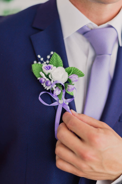 Ochtendbruidegom, Bruidegom in een jasje, De bruidegom maakt het knoopsgat recht, trouwdag. - Foto, afbeelding