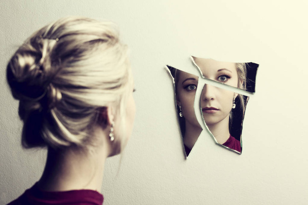 Γυναίκα ψάχνει το πρόσωπό της στα τρία θραύσματα κομμάτια σπασμένου καθρέπτη - Φωτογραφία, εικόνα