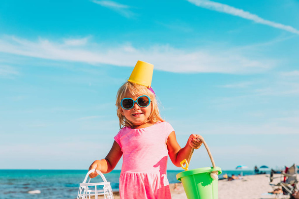 cute little girl with toys on public beach - Photo, Image