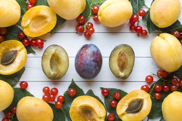 Świeża śliwka, morela i Czerwona porzeczka jagody z liści na stół - Zdjęcie, obraz