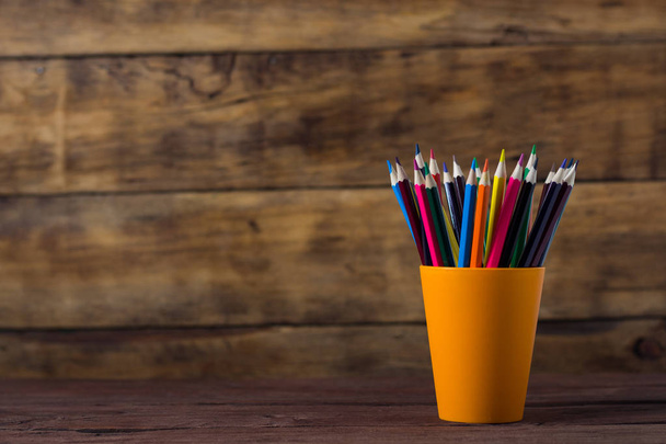 Colored Pencils In Orange Grocery on Wooden Background. Copy space. - Foto, imagen