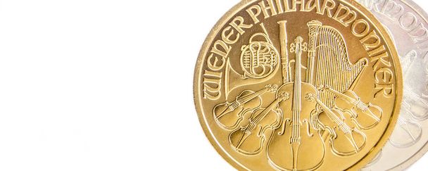 крупним планом срібної та Золотий австрійський philharmoniker одна унція монети на білому тлі, розміщені на правій стороні - Фото, зображення