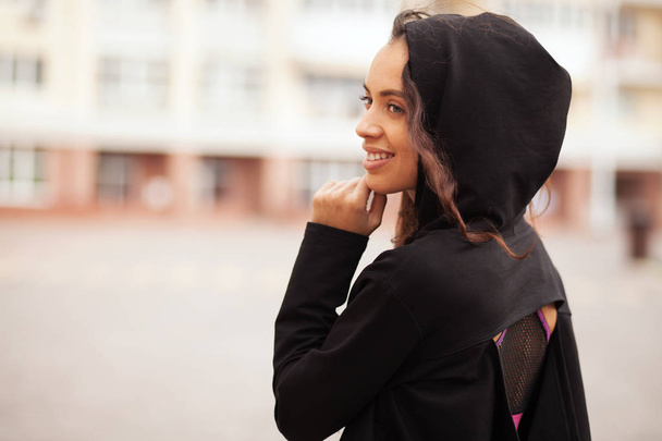 Outdoor portrait of a beautiful sporty woman in black hoody - Fotografie, Obrázek