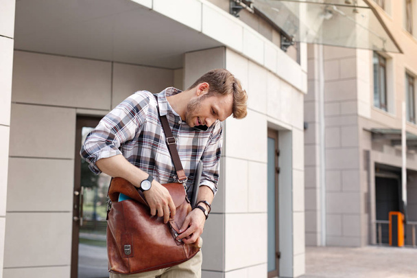 Handsome young man closing his bag - 写真・画像