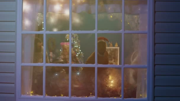 Opgewonden vrienden uitkijken in venster tijdens Kerstmis - Video