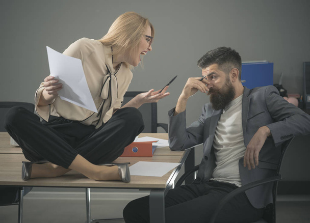 Business woman and bearded man work together in office. Business woman and businessman write corporate report, busy day in office - Foto, Imagen