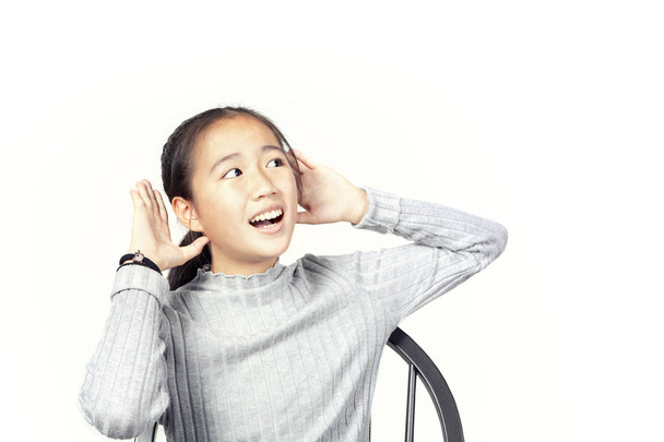 asiático adolescente levantar mão até ouvir isolado branco fundo
 - Foto, Imagem