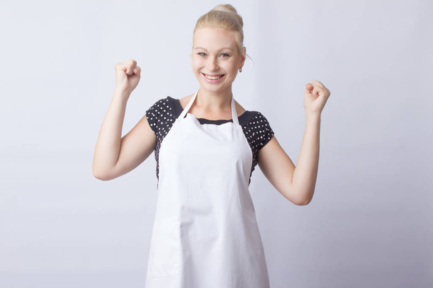 cute blonde woman in white apron posing on white background. cook. a housewife - Valokuva, kuva