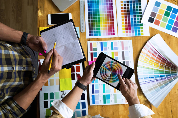 Графические дизайнеры используют планшет для выбора цветов из примера цветовой панели для дизайнерских идей, творческих дизайнов концепции графических дизайнеров
. - Фото, изображение