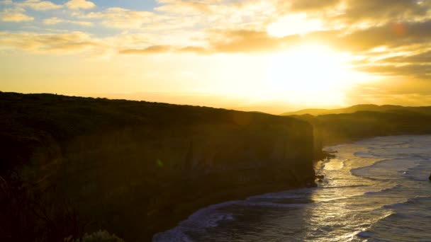 Sabah güneş ışığı kireçtaşı kayalıklarla şafakta Victoria Australia on iki havari deniz Milli Park manzaralı kıyı şeridi üzerinde - Video, Çekim